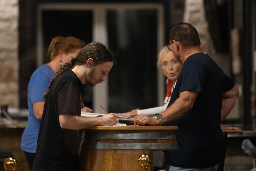 Ballots are counted by hand on top of wine barrels at The Edge in Fredericksburg on Mar. 5, 2024. Election workers had been counting ballots since 7 a.m.